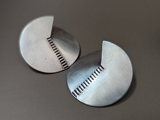 Brushed and stamped silver 925 circular earrings with subtle notch and linear pattern. Modern and élégant handcrafted jewelry by Anajo Designs, made in California.