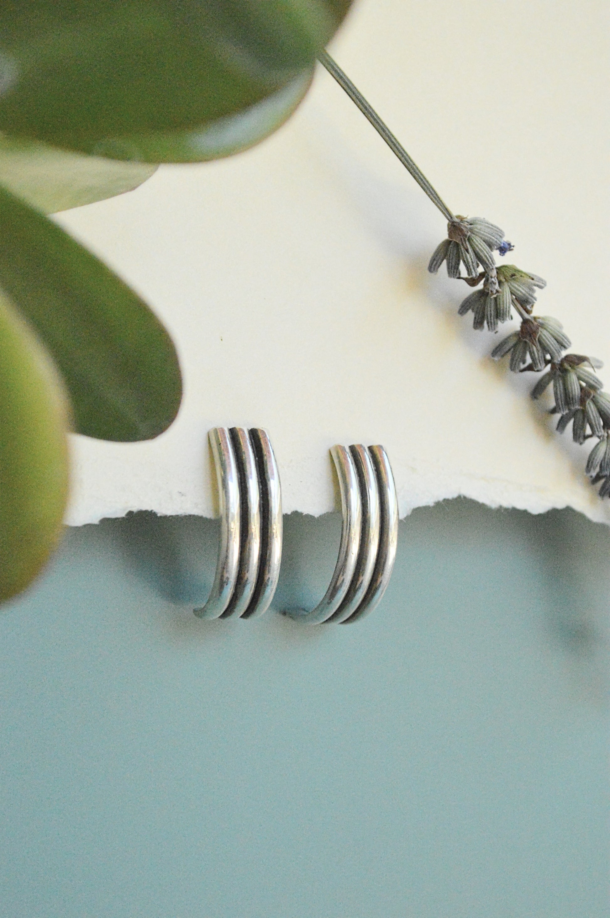 handmade semi hoops earrings in sterling silver and brass, minimalist designs and lightweight. Made by designer