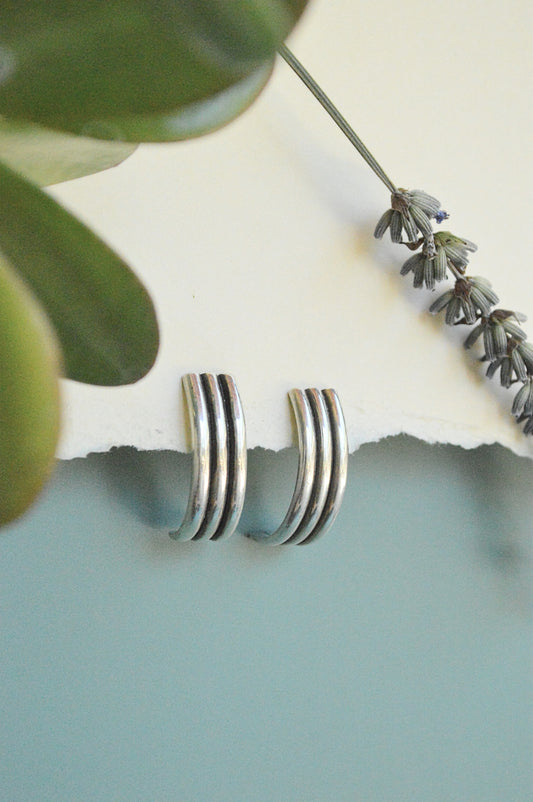 handmade semi hoops earrings in sterling silver and brass, minimalist designs and lightweight. Made by designer